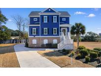 Two-story blue house with brick base, white trim, and a walkway at 3714 Old Pointe Circle, North Myrtle Beach, SC 29582