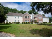 Brick and white exterior of a two-story building with landscaping at 4309 Lotus Ct. # G, Murrells Inlet, SC 29576