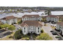 Aerial view of a waterfront community with multiple buildings and parking at 4634 Greenbriar Dr. # Apt E3, Little River, SC 29566