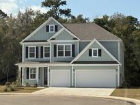 Two-story house with light blue siding, two-car garage, and landscaped yard at 558 Haven View Way, Murrells Inlet, SC 29576