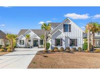 Two-story farmhouse with white siding, dark accents, and palm trees at 5913 Country Club Dr., Myrtle Beach, SC 29577