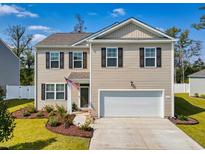 Two-story house with beige siding, white garage door, and landscaped front yard at 623 Meadowgrass Ct., Myrtle Beach, SC 29588