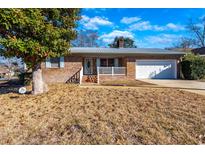 Brick ranch home with attached garage, front porch, and mature landscaping at 1020 Thomas Ave., North Myrtle Beach, SC 29582