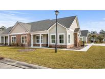 Craftsman style home with a light beige exterior, stone accents, and a covered porch at 127 Stonewall Circle # 6-4, Longs, SC 29568