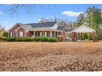 Brick home with covered porch and detached carport, surrounded by manicured landscaping at 3618 Highway 430, Nichols, SC 29581