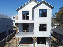 New construction home featuring a modern design with large windows, a gray exterior, and an open lower level at 4617 Hedrick St., North Myrtle Beach, SC 29582