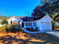 White house with attached garage and landscaped yard at 49 Daniel Morrall Ln., Georgetown, SC 29440