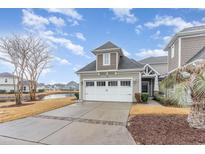 Charming home exterior with a two-car garage, driveway, and lush landscaping with water view at 6244 Catalina Dr. # 1411, North Myrtle Beach, SC 29582