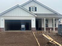 Charming new construction home featuring a brick-accented facade, covered porch, and an attached two-car garage at 1245 Crested Iris Way, North Myrtle Beach, SC 29582