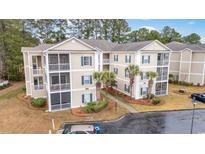 Tan two-story condo building with balconies and parking at 248 Sun Colony Blvd. # A-305, Longs, SC 29568