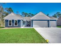 Charming home featuring a two-car garage, crisp blue siding, and a well-manicured green lawn at 25 Northbrook Dr, Murrells Inlet, SC 29576