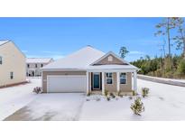 Tan house with white garage door, snow covered yard at 281 Columbus St., Conway, SC 29526