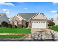 Charming single-story home with a brick facade, well-manicured lawn, and attached two-car garage at 3141 Shorecrest Bay Dr., Murrells Inlet, SC 29576