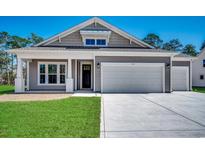Charming single-story home with a two-car garage, manicured lawn, and Craftsman-style details at 35 Northbrook Dr, Murrells Inlet, SC 29576