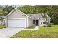 Tan house with a white garage door and a well-maintained lawn at 363 Junco Circle, Longs, SC 29568