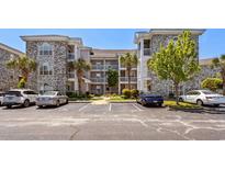 Brick building exterior with ample parking and landscaping at 4725 Wild Iris Dr. # 202, Myrtle Beach, SC 29577