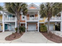 Inviting coastal townhome with two-story design, attached garage, and palm trees at 4919 Cinzia Ln. # 6-B, North Myrtle Beach, SC 29582