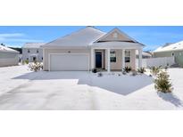 Snow covered home's exterior features a garage and front porch at 708 Canton St., Conway, SC 29526