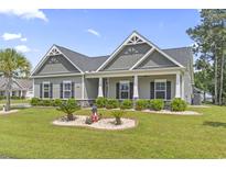 Charming single-story home boasts a welcoming porch and well-manicured lawn with decorative landscaping at 901 Queensferry Ct., Conway, SC 29526