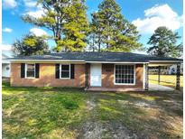Charming brick home featuring large front window and convenient carport at 109 S Maple Ave., Andrews, SC 29510