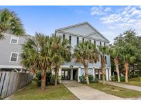 Two-story house with light blue siding, palm trees, and a paved driveway at 117 A N Dogwood Dr., Surfside Beach, SC 29575