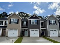 Charming townhomes with garages and contemporary architectural style under a blue sky at 261 Christiana Ln. # D, Myrtle Beach, SC 29579