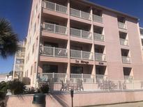 Three-story building with multiple balconies and a light pink exterior at 2710 Ocean Blvd. S # 406, Myrtle Beach, SC 29577
