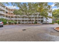 Condominium complex featuring multiple levels, ample parking, and mature shade trees at 415 Ocean Creek Dr. # 2139, Myrtle Beach, SC 29572