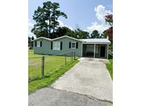 Green house with a spacious yard and driveway at 109 Plum Ln., Andrews, SC 29510