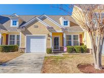 Beautiful yellow two-story home with a white garage door and landscaping at 306 River Rock Ln. # 1304, Murrells Inlet, SC 29576