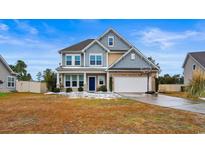 Two-story house with gray siding, stone accents, and a basketball hoop at 3220 Saddlewood Circle, Myrtle Beach, SC 29579
