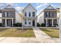 Three-story townhouses with brick and white siding, front yards, and sidewalks at 3525 Bristol Ln., Myrtle Beach, SC 29577