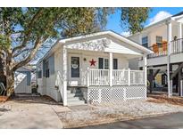 Charming white cottage with front porch and small yard at 6001-1235 S Kings Highway, Myrtle Beach, SC 29575