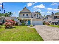 Charming two-story home features a well-manicured lawn, attached garage, and inviting blue front door at 637 Sparrow Dr., Surfside Beach, SC 29575