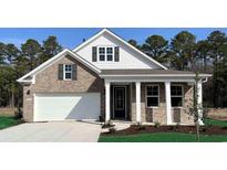 Brick home with a white garage door and a covered porch at 7093 Shooting Star Way, Myrtle Beach, SC 29579