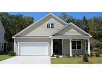 Tan house with white garage door and landscaping at 7097 Shooting Star Way, Myrtle Beach, SC 29579