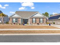 Charming single-story home featuring stone accents and a well-manicured lawn on a sunny day at 980 Desert Wheatgrass Dr., Myrtle Beach, SC 29579