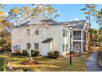 Light yellow multi-unit building with landscaping and walkway at 143 Crane Dr. # A, Pawleys Island, SC 29585