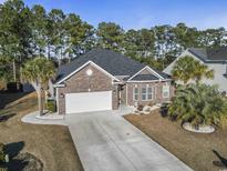Brick house with 2-car garage, landscaping, and long driveway at 144 Shenandoah Dr., Murrells Inlet, SC 29576