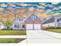 Charming two-story home featuring a brick facade, two-car garage, and manicured front lawn at 217 Appian Way, Myrtle Beach, SC 29588
