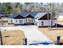 Modern farmhouse exterior boasts a two-car garage and welcoming front porch at 232 Ole Maple St., Loris, SC 29569