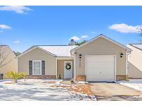 Beige house with a two-car garage and a snow-covered yard at 3102 Regency Oak Dr., Myrtle Beach, SC 29579