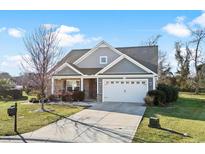 Gray house with stone accents, white garage door, and landscaping at 417 San Benito Ct., Longs, SC 29568