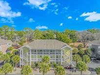 Aerial view of a two-story building with surrounding palm trees and lush landscaping at 4281 Hibiscus Dr. # 2-102, Little River, SC 29566