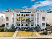 Three-story condo building with ample parking and lush landscaping at 612 River Oaks Dr. # 55-C, Myrtle Beach, SC 29579