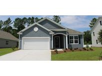 Gray house with white garage door, landscaping, and a paved driveway at 811 Ireland Dr., Longs, SC 29568