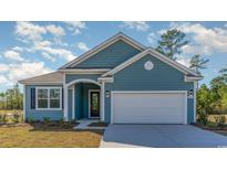 Two-story house with blue siding, white garage door, and landscaping at 822 Ireland Dr., Longs, SC 29568