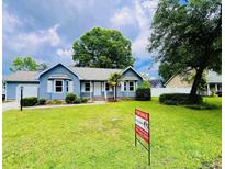 Charming home features a landscaped front yard with a 'For Sale' sign at 104 Willow Ridge Rd., Myrtle Beach, SC 29588