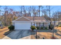 Tan house with white garage door and landscaping at 1240 Pineridge St., Conway, SC 29527