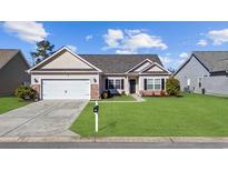 Charming single-story home with a well-manicured lawn, attached garage, and welcoming curb appeal at 129 Yeomans Dr., Conway, SC 29526